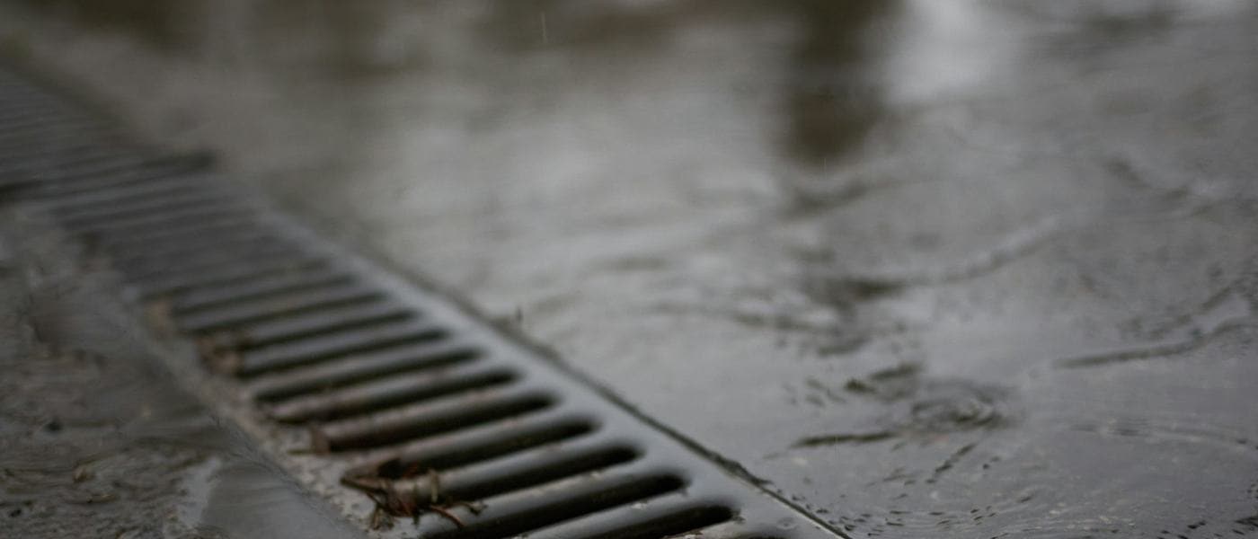 Rainwater draining through a street grate in Kampala